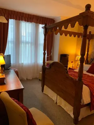 a bedroom with a canopy bed and a desk at The Old Coach House in Blackpool