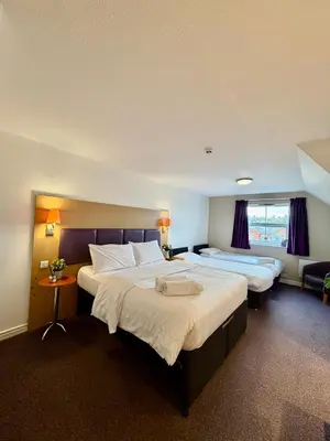 a hotel room with two beds and a window at Premier Nights, Wigan, Standish M6 J27 in Standish