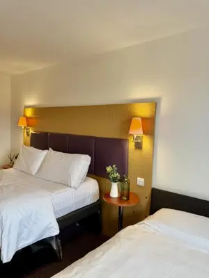 a hotel room with two beds and a table at Premier Nights, Wigan, Standish M6 J27 in Standish