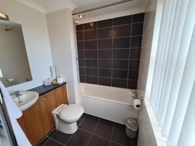 a bathroom with a toilet and a tub and a sink at The Royal Hotel in Liverpool