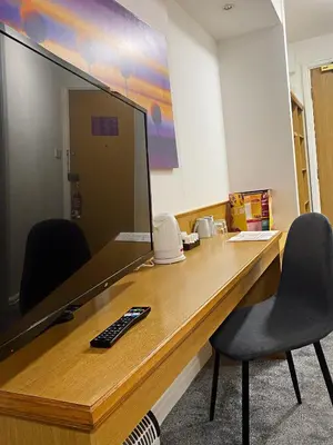 a desk with two chairs and a computer monitor at Purple Roomz Preston South in Preston