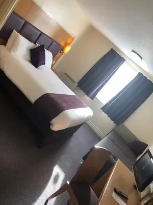 a hotel room with a bed and a window at Purple Roomz Preston South in Preston