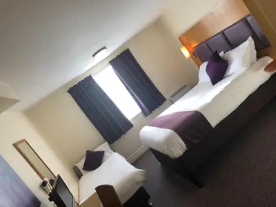 a hotel room with two beds and a window at Purple Roomz Preston South in Preston
