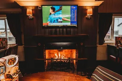a living room with a fireplace and a flat screen tv at Purple Roomz Preston South in Preston