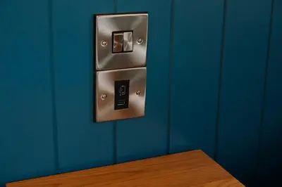 a metal switch on a blue wall with a wooden table at The Bay Horse Hotel in Haydock