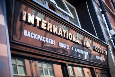 a sign for the entrance to the backpacksbestos house and engineer at International Inn in Liverpool
