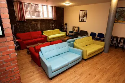 a living room with four couches and chairs at International Inn in Liverpool