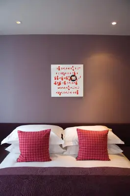 a bedroom with a bed with red and white pillows at The Midland in Morecambe