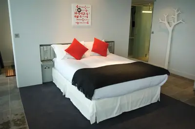 a bedroom with a large bed with red pillows at The Midland in Morecambe
