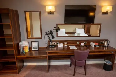 a desk in a room with a bed and a mirror at The Fernhurst by Greene King Inns in Blackburn