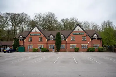 a large red brick building with a parking lot at The Fernhurst by Greene King Inns in Blackburn