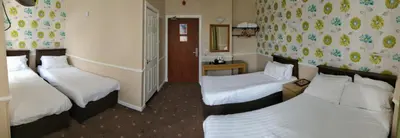 a hotel room with three beds in it at The Lawton in Blackpool