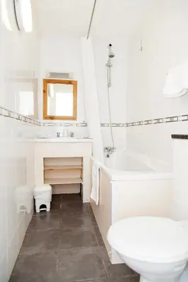 a white bathroom with a sink and a tub and a toilet at The Lawton in Blackpool