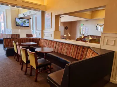 a restaurant with tables and chairs and a mirror at The Beechfield Hotel in Blackpool