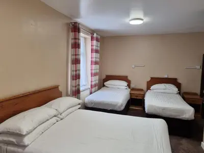 a bedroom with two beds and a window at The Beechfield Hotel in Blackpool