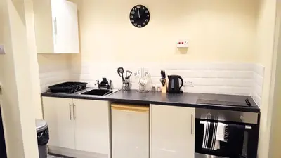 a kitchen with a counter and a clock on the wall at St Nicholas Holiday Apartments in Blackpool