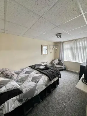a bedroom with a bed and a couch in it at St Nicholas Holiday Apartments in Blackpool