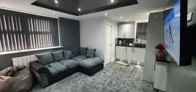 a living room with a couch and a flat screen tv at St Nicholas Holiday Apartments in Blackpool