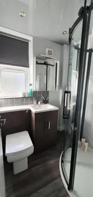 a bathroom with a toilet and a sink and a shower at St Nicholas Holiday Apartments in Blackpool