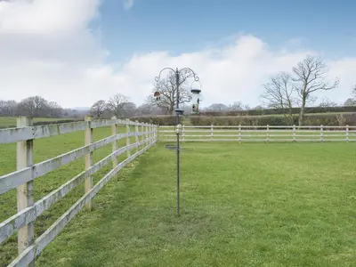 a fence with a pole in the middle of a field at Five Barred Gate Barn in Inglewhite