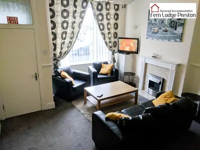 a living room with two couches and a fireplace at 4 Bedroom House at Fern Lodge Preston Serviced Accommodation - Free WiFi & Parking in Preston