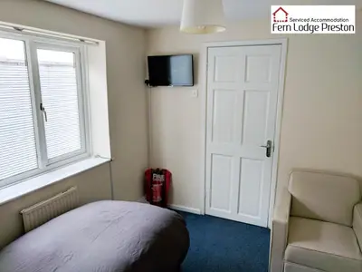 a bedroom with a bed and a window and a door at 4 Bedroom House at Fern Lodge Preston Serviced Accommodation - Free WiFi & Parking in Preston