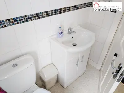 a white bathroom with a toilet and a sink at 4 Bedroom House at Fern Lodge Preston Serviced Accommodation - Free WiFi & Parking in Preston
