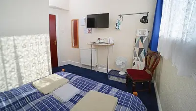 a small room with a bed and a chair at Lynmoore Guest House in Blackpool