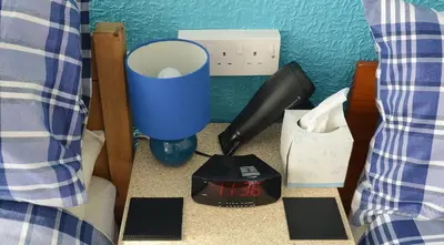 a blue cup and a hair dryer on a counter at Lynmoore Guest House in Blackpool