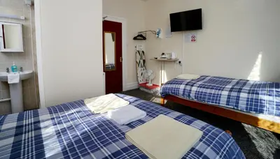 a room with two beds and a sink at Lynmoore Guest House in Blackpool