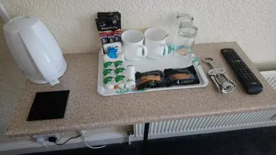 a table with a tray of food and a remote control at Lynmoore Guest House in Blackpool