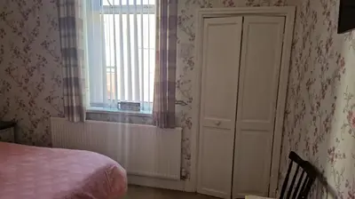 a bedroom with a bed and a window at OYO Wynnstay Hotel in Blackpool