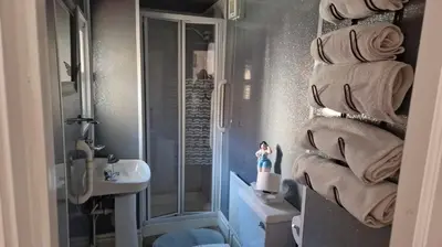 a bathroom with a sink and a pile of towels at OYO Wynnstay Hotel in Blackpool