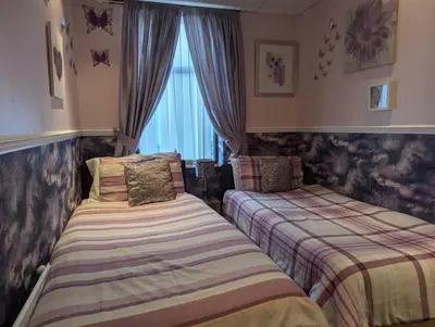 a bedroom with two beds and a window at OYO Wynnstay Hotel in Blackpool