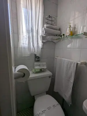 a small bathroom with a toilet and towels at OYO Wynnstay Hotel in Blackpool