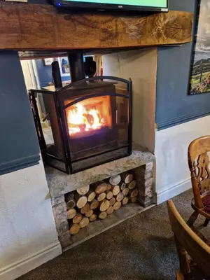 a wood burning stove in a living room at The Lord Nelson Inn B&B in Langho