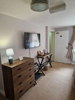 a room with a dresser and a desk with a television at The Lord Nelson Inn B&B in Langho