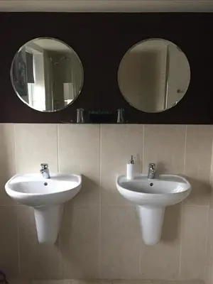 a bathroom with two sinks and two mirrors at EsJays at Knowles House in Lytham St Annes