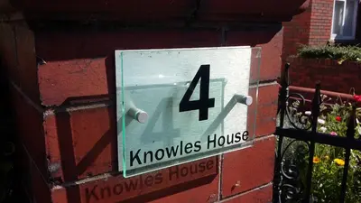 a sign on the side of a brick building with the number house at EsJays at Knowles House in Lytham St Annes