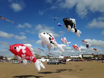 a bunch of kites flying in the sky on a beach at EsJays at Knowles House in Lytham St Annes