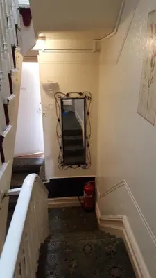 a stairway with a mirror on the wall at Wishing Well Guest House in Blackpool