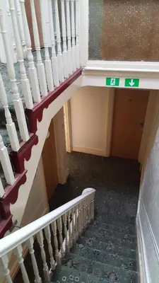 a stairway in a building with a sign on it at Wishing Well Guest House in Blackpool