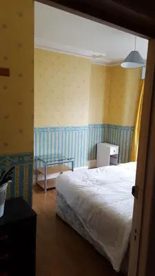 a bedroom with a white bed and yellow walls at Wishing Well Guest House in Blackpool