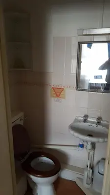 a small bathroom with a toilet and a sink at Wishing Well Guest House in Blackpool