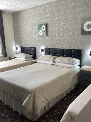 a bedroom with two beds and a wall at Myrtle house in Blackpool