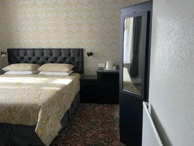 a bedroom with a bed with a black headboard and a mirror at Myrtle house in Blackpool