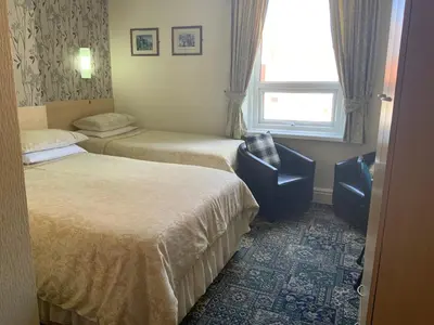 a hotel room with two beds and a window at Myrtle house in Blackpool