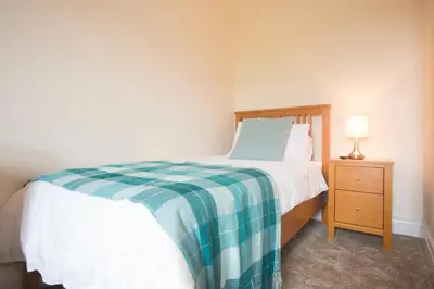 a small bedroom with a bed and a night stand at Stanley Lodge Farmhouse in Cockerham