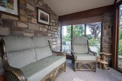 a living room with a couch and two chairs at Stanley Lodge Farmhouse in Cockerham