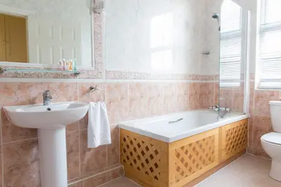 a bathroom with a sink and a tub and a toilet at Promenade Apartments in Southport